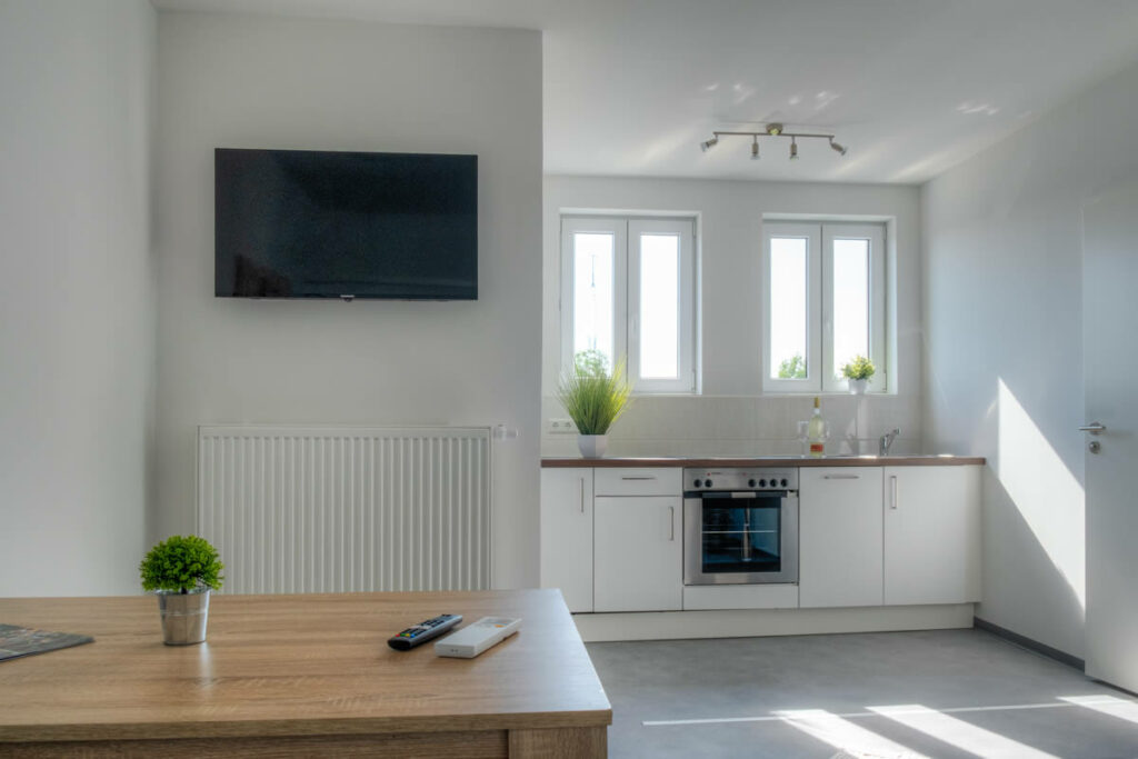 Helle Wohnküche mit Esstisch und TV